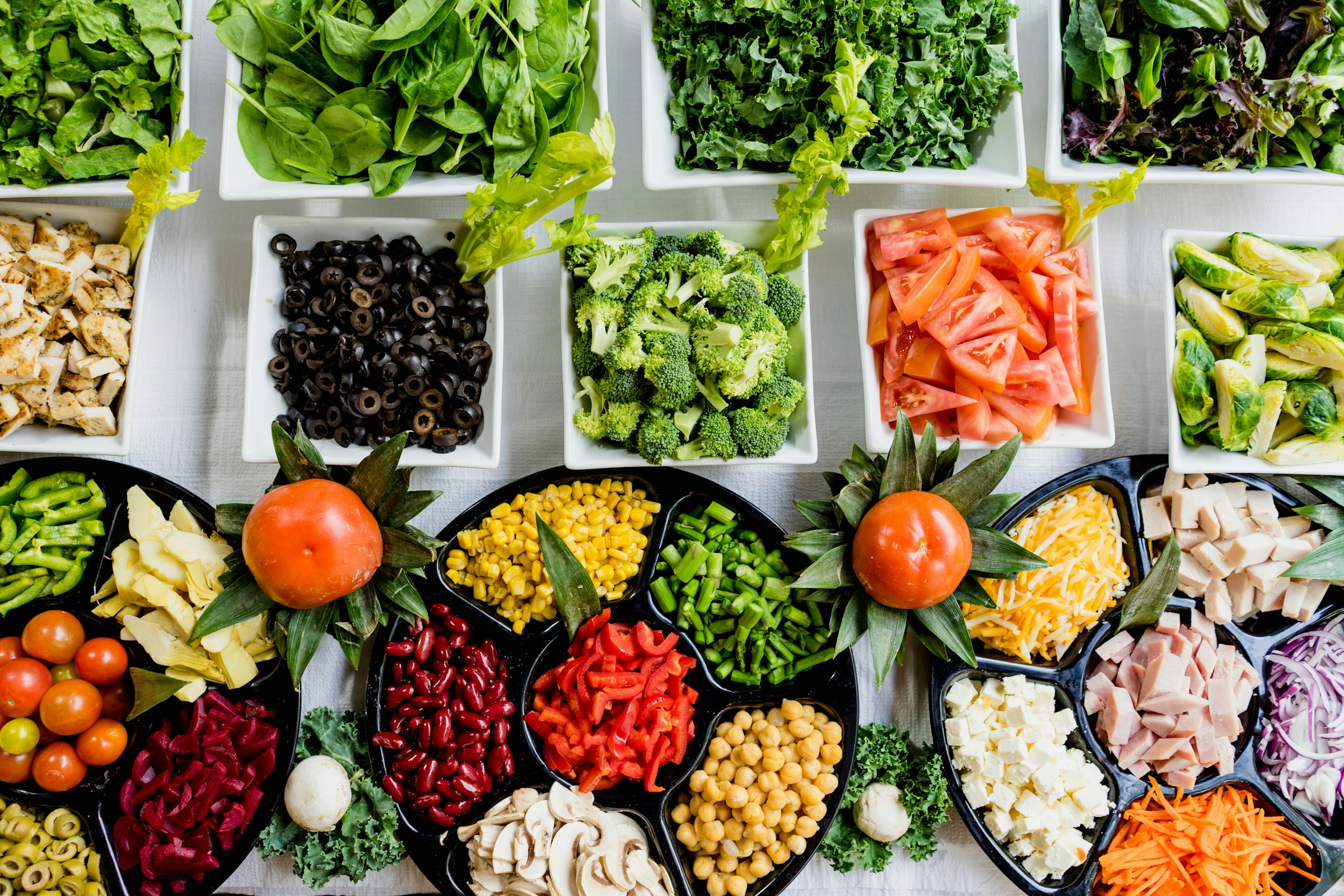 Fresh greens, fruit, and natural ingredients arranged on a bright kitchen surface